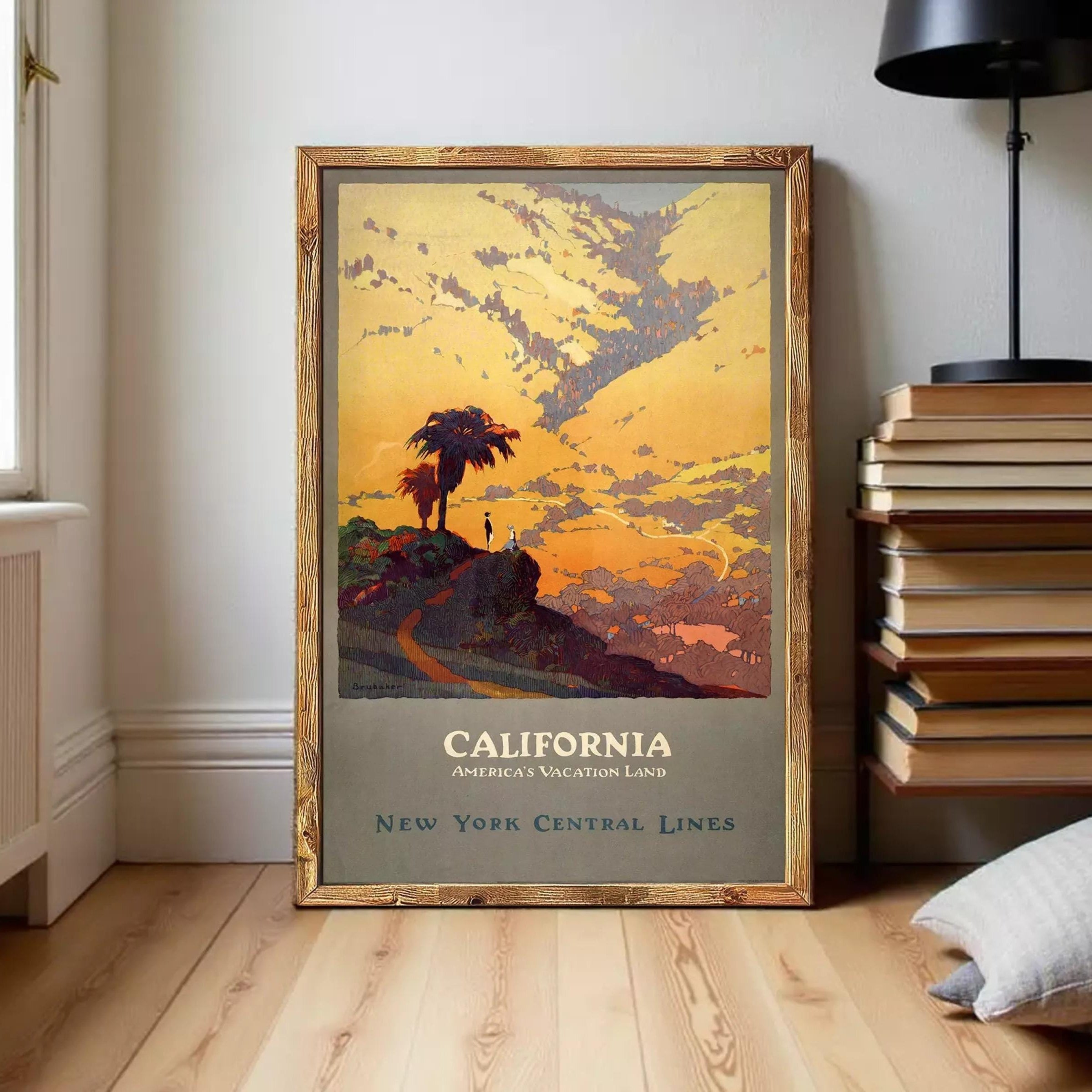 A framed vintage poster depicting a scenic landscape with a palm tree, mountains, and a sunset sky, advertising California as a vacation land.