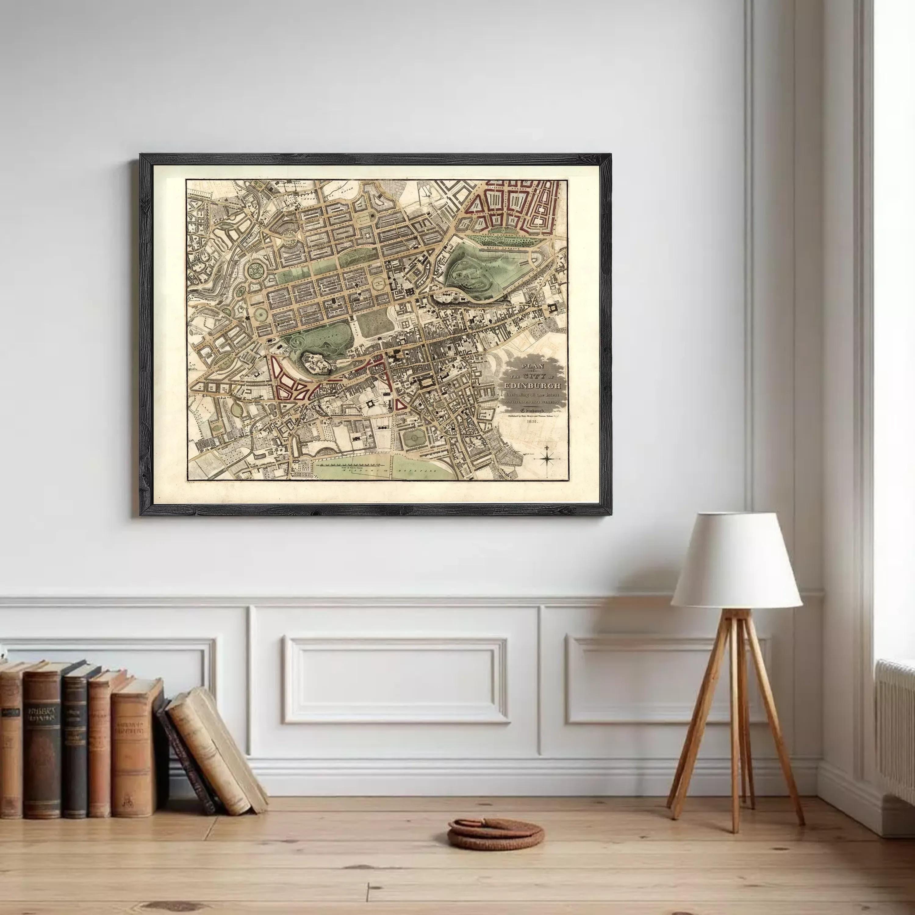 a framed map of a city hanging on a wall, with a lamp and a stack of books placed nearby.