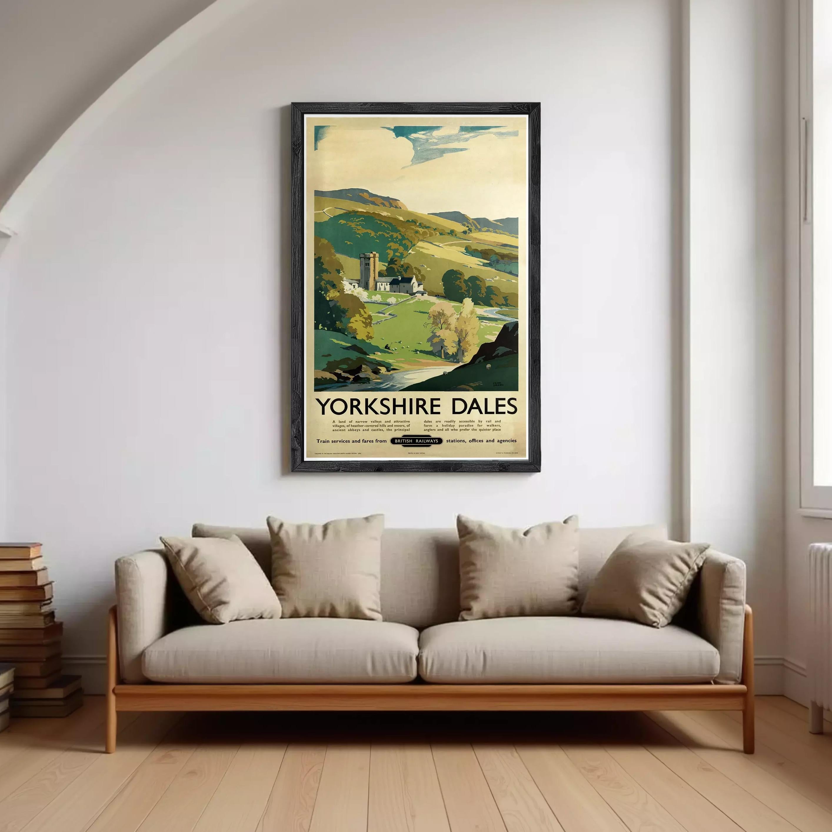 A framed vintage travel poster advertising Yorkshire Dales, featuring a scenic countryside landscape with a church, trees, and a winding river.