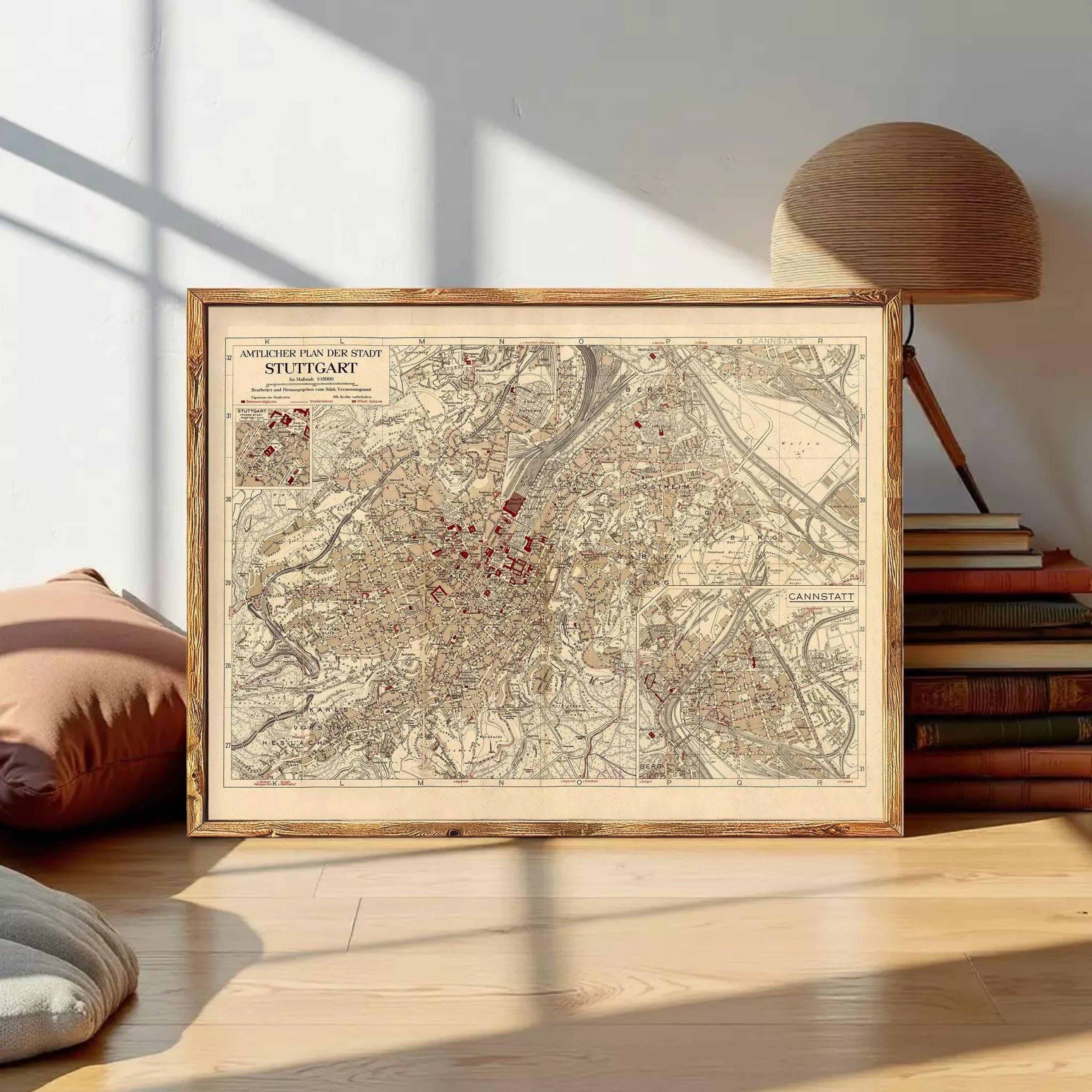 a framed map of Stuttgart, Germany, with a wooden lamp and a stack of books in the background.