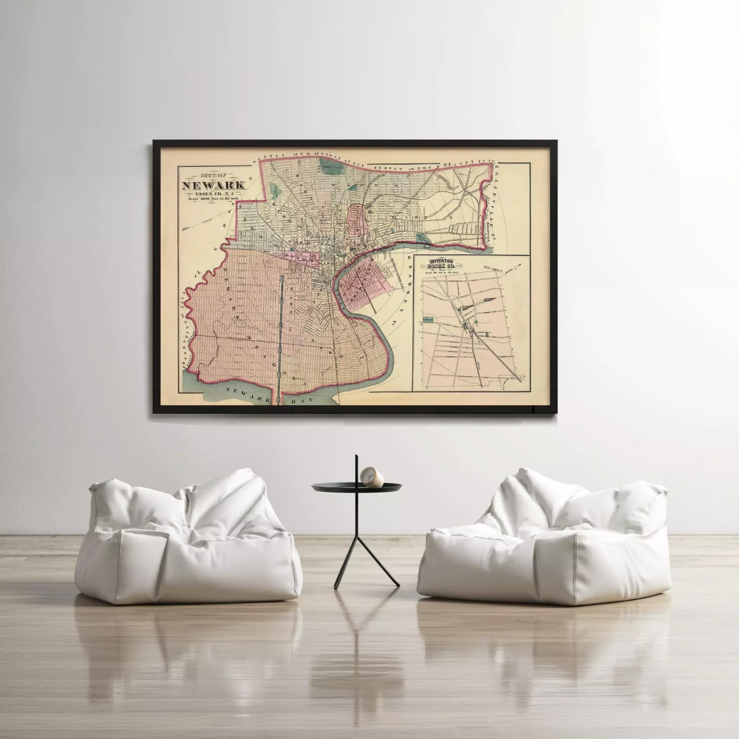 a large framed map of New York City hanging on a white wall, with two white bean bag chairs positioned in front of it.