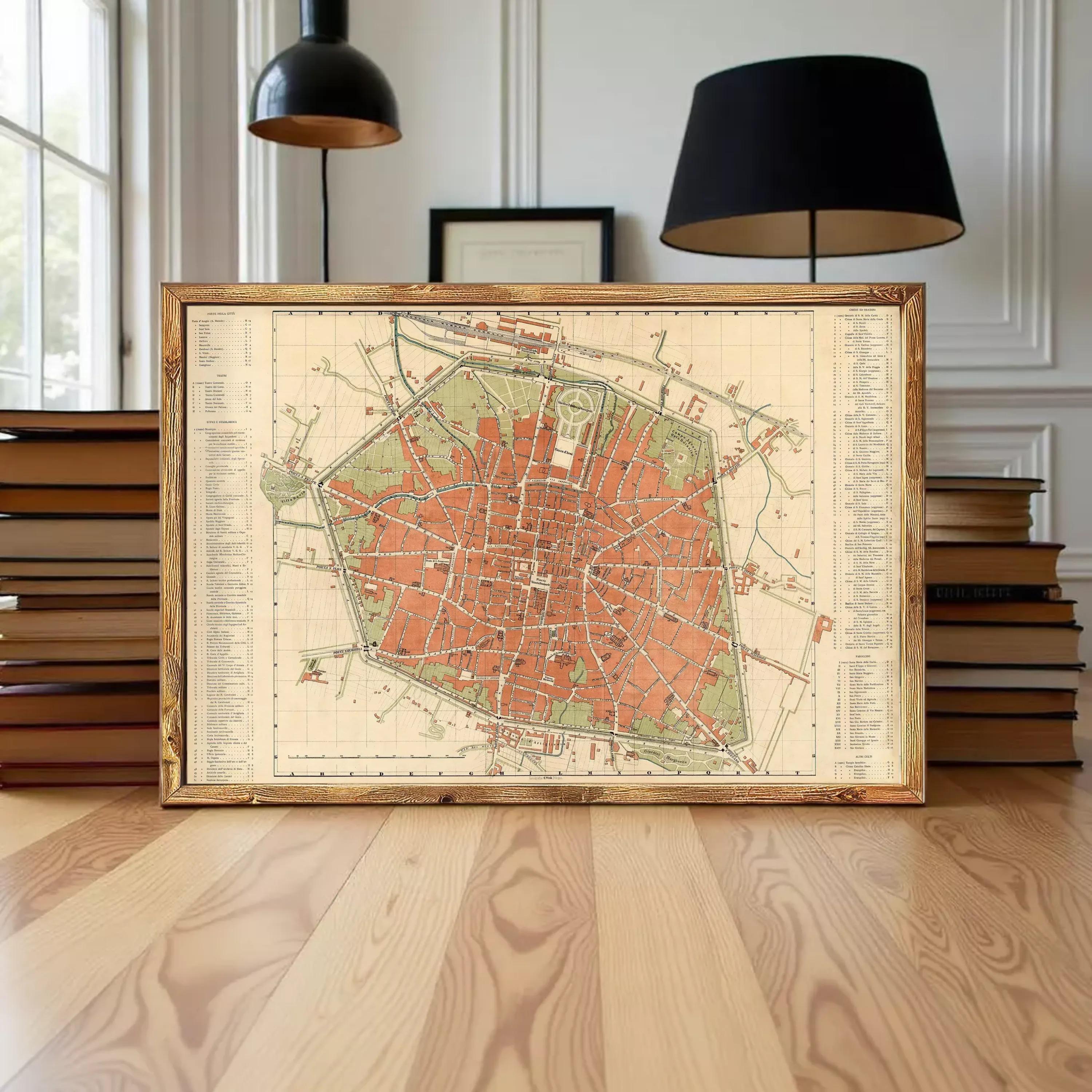 a framed map of a city, with a wooden floor and a stack of books in the background.