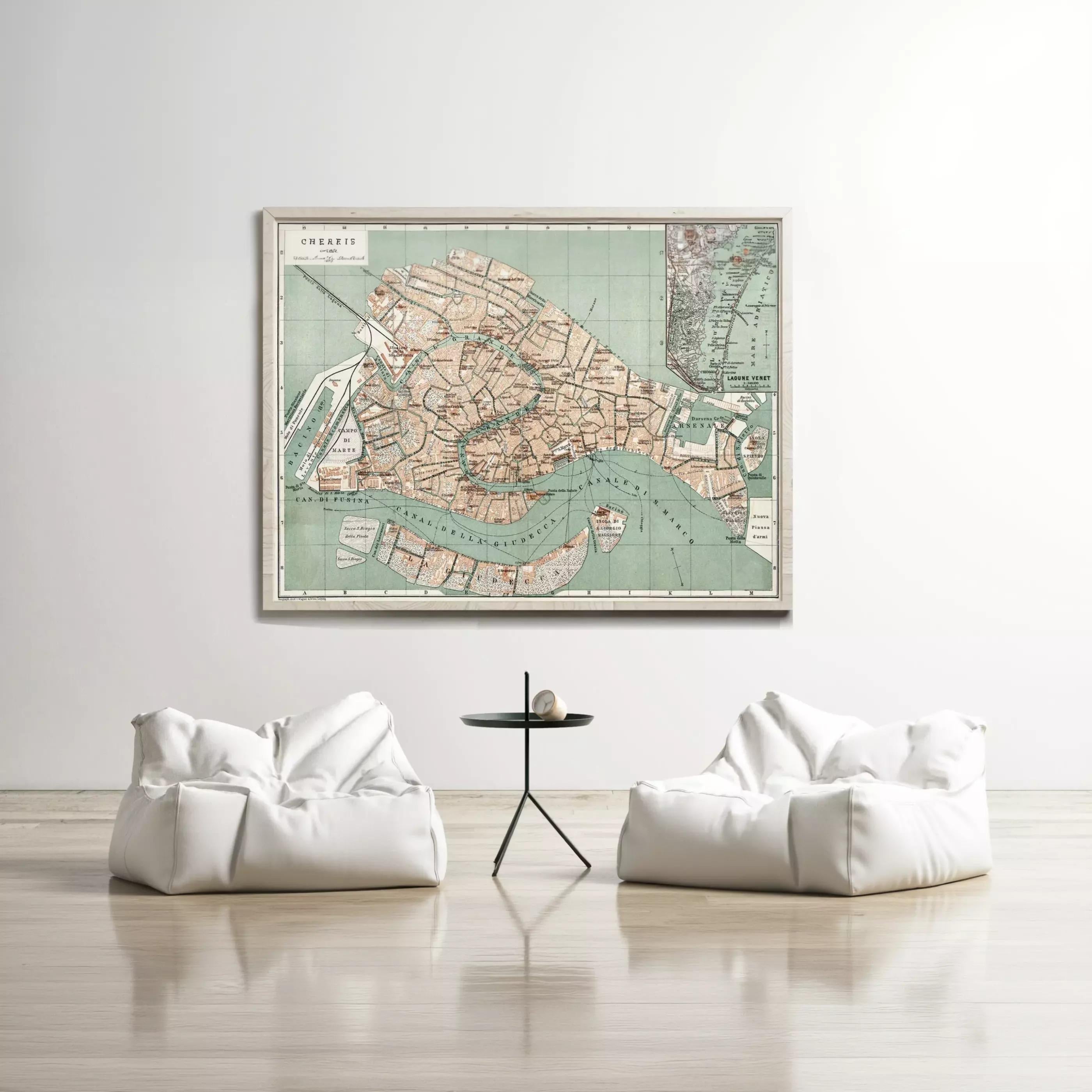 a large framed map of Venice hanging on a white wall, with two white bean bag chairs positioned in front of it.