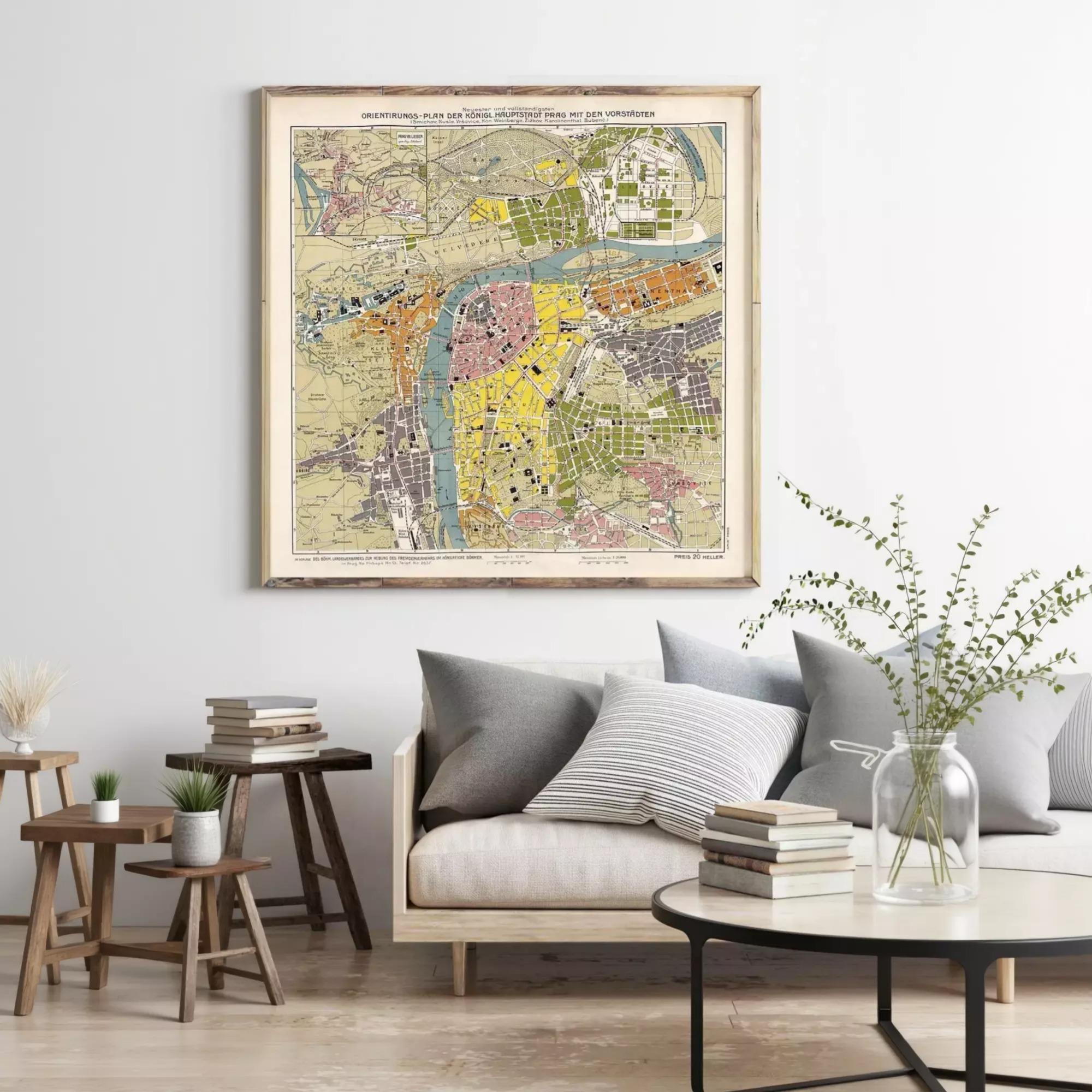 a large framed map of a city hanging on a wall above a couch with pillows and a coffee table in a living room setting.