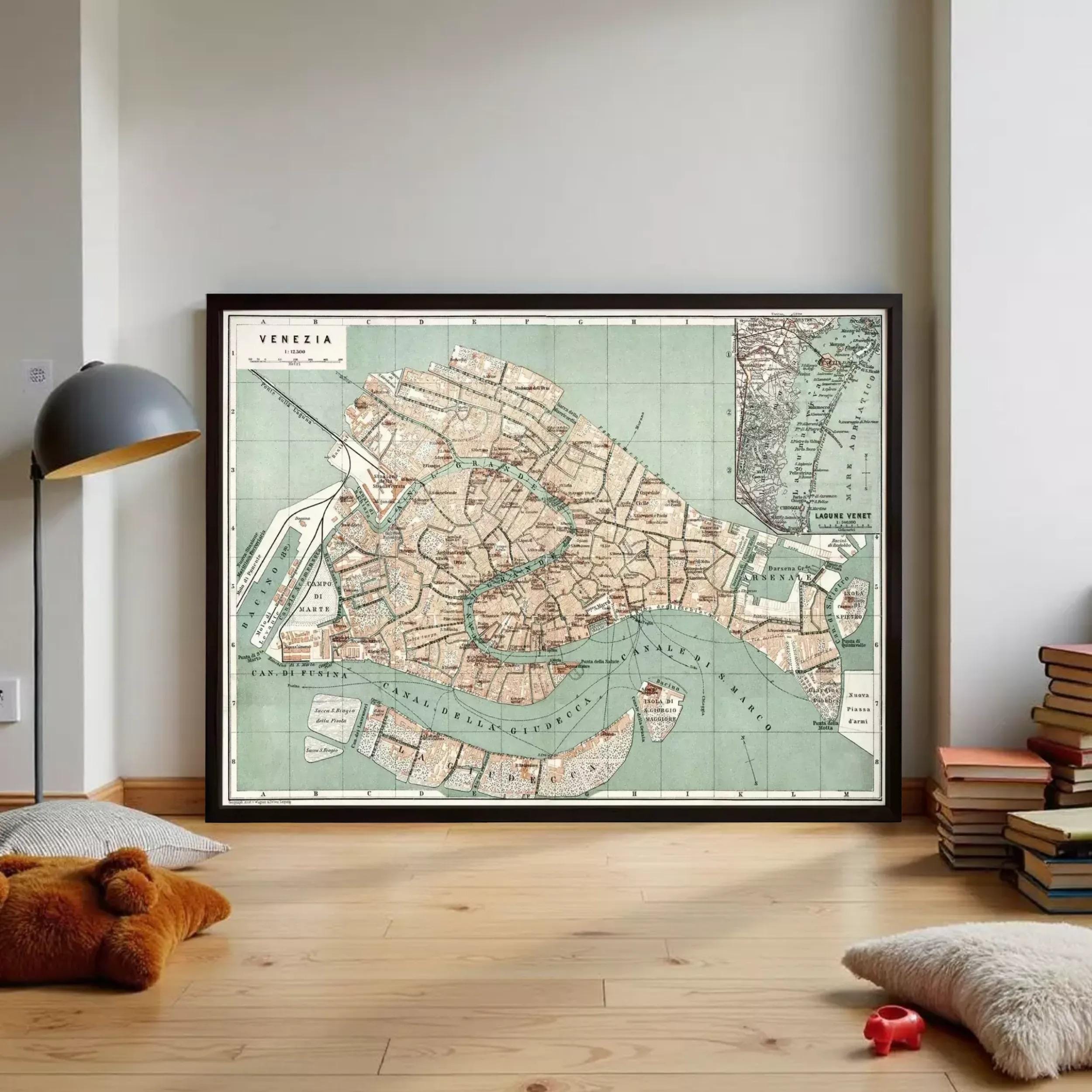 a large framed map of Venice, Italy, with a vintage style and a green and white color scheme. The map is displayed on a wall in a room with a lamp and some books.