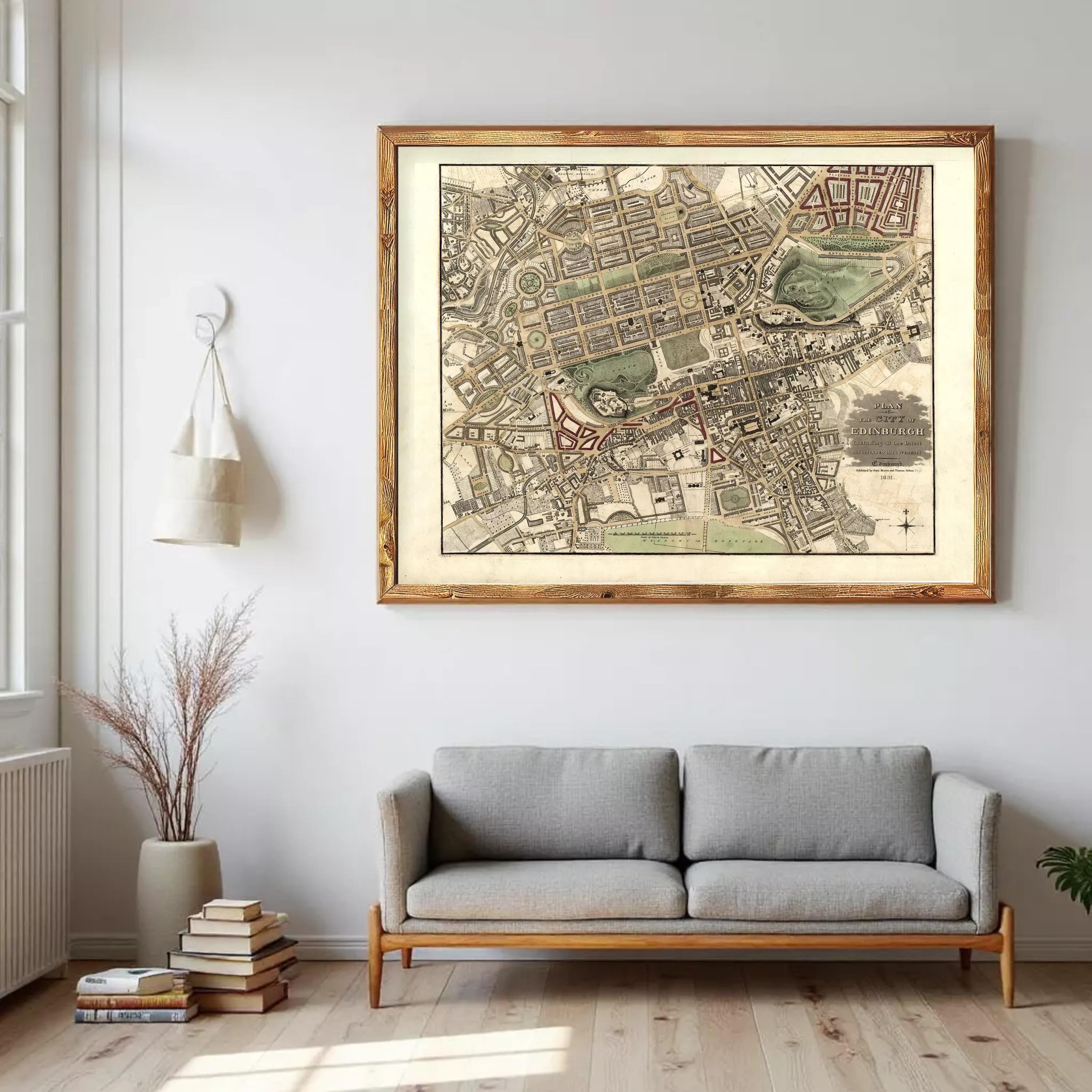 a large, framed map of a city hanging on a wall above a gray sofa in a living room.