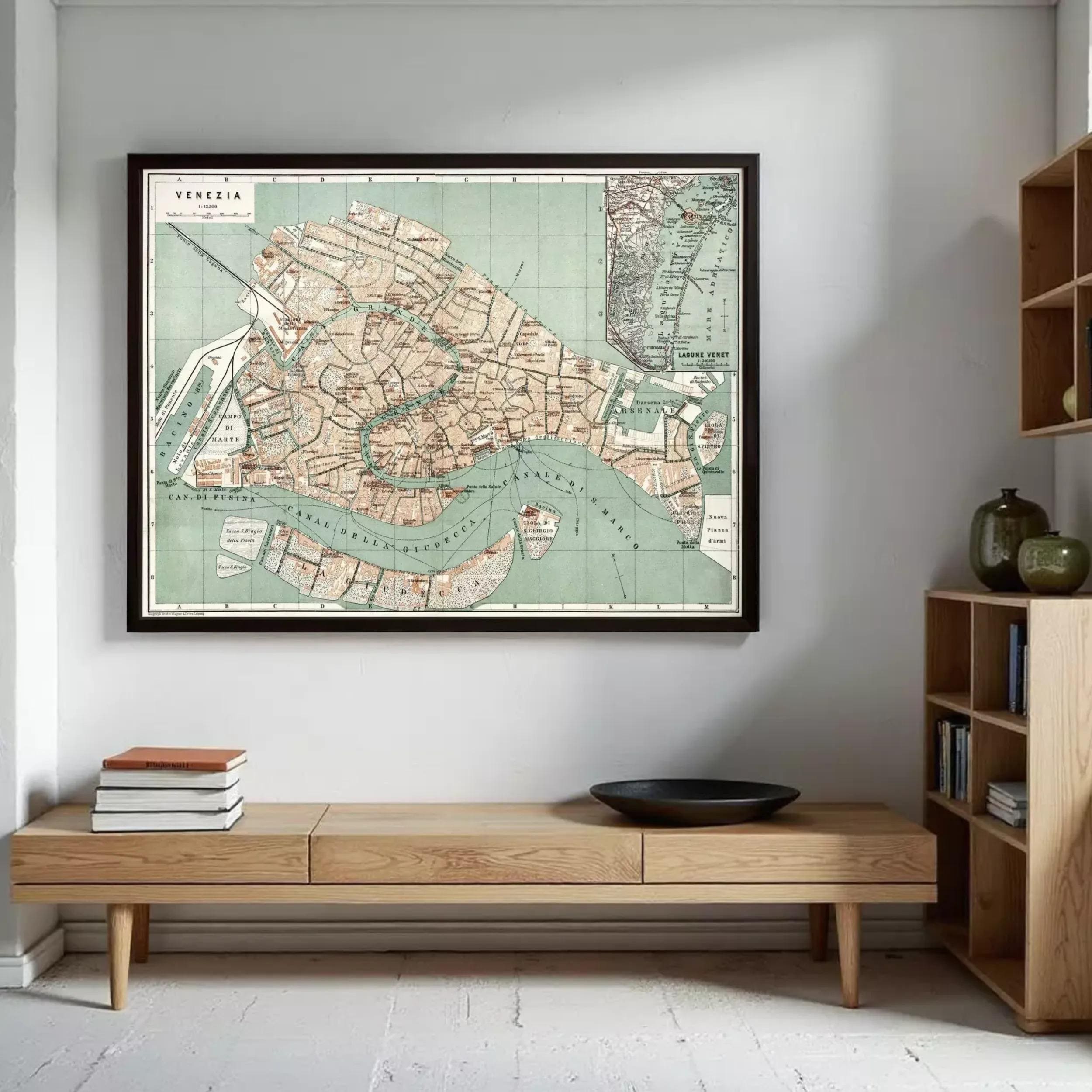 a large framed map of Venice hanging on a wall, with a wooden bench and a stack of books placed in front of it.