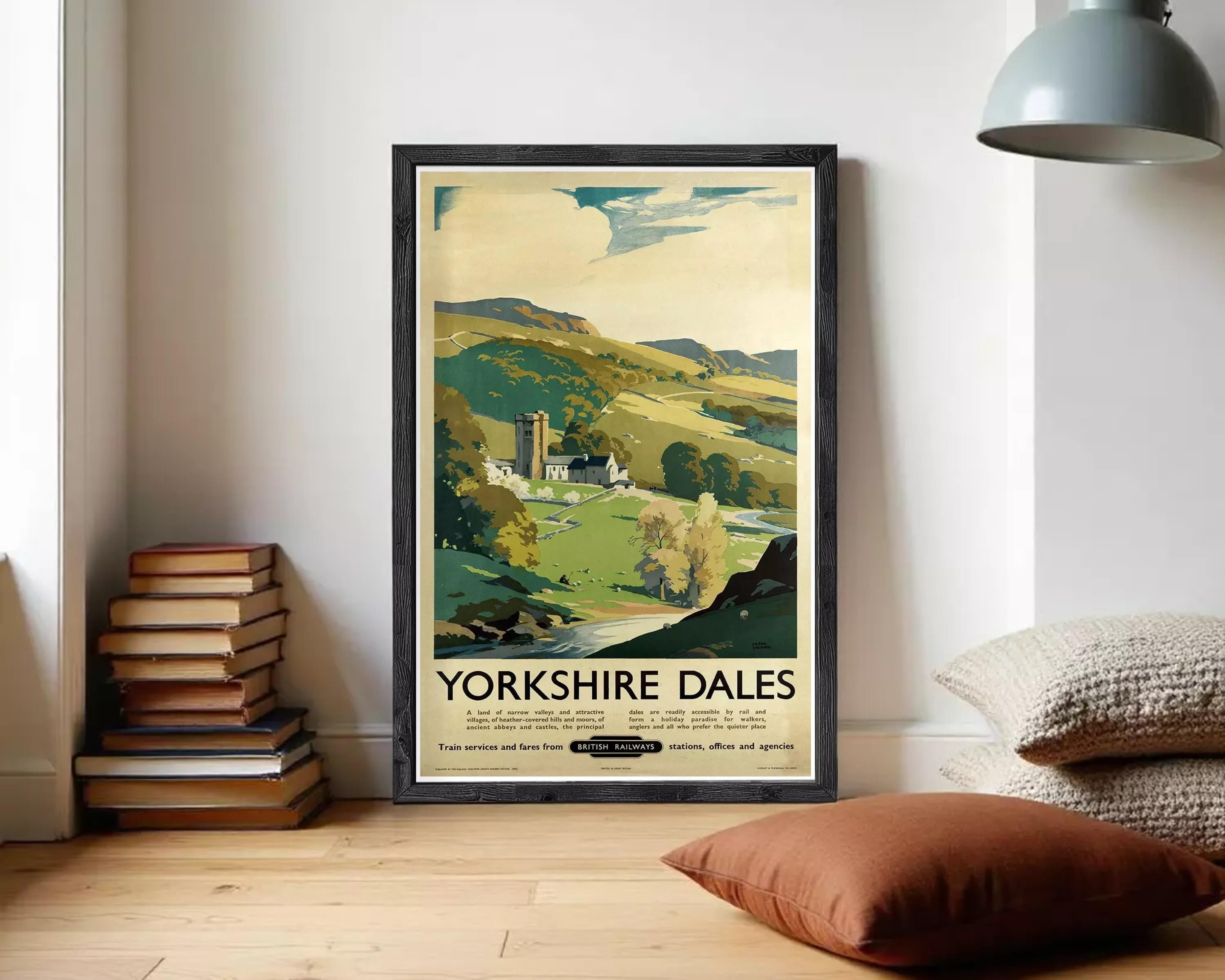 A framed vintage travel poster advertising Yorkshire Dales, featuring a scenic countryside landscape with a church, trees, and a winding river.