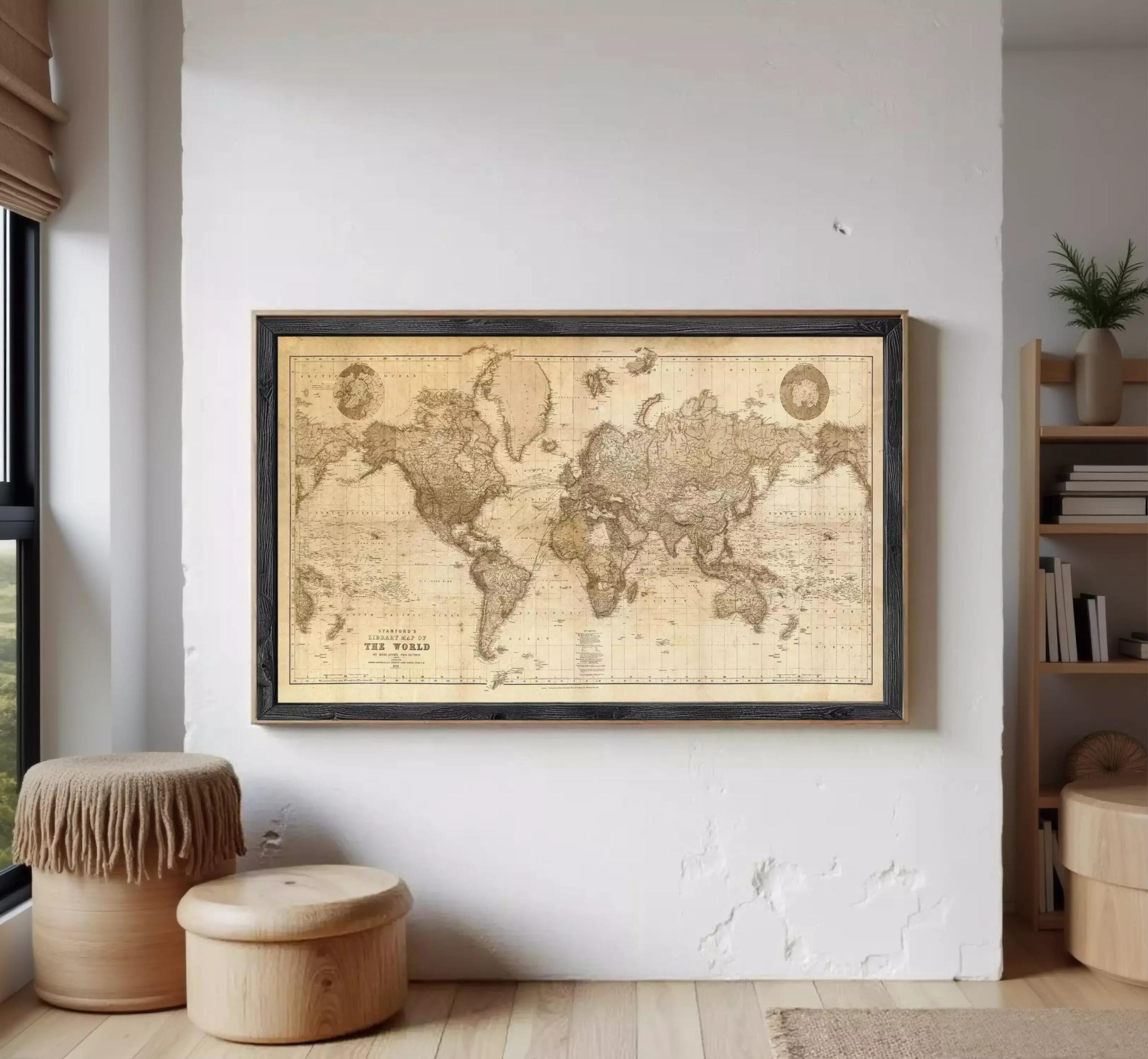 a large world map hanging on a white wall, with a wooden stool and a plant in the foreground.