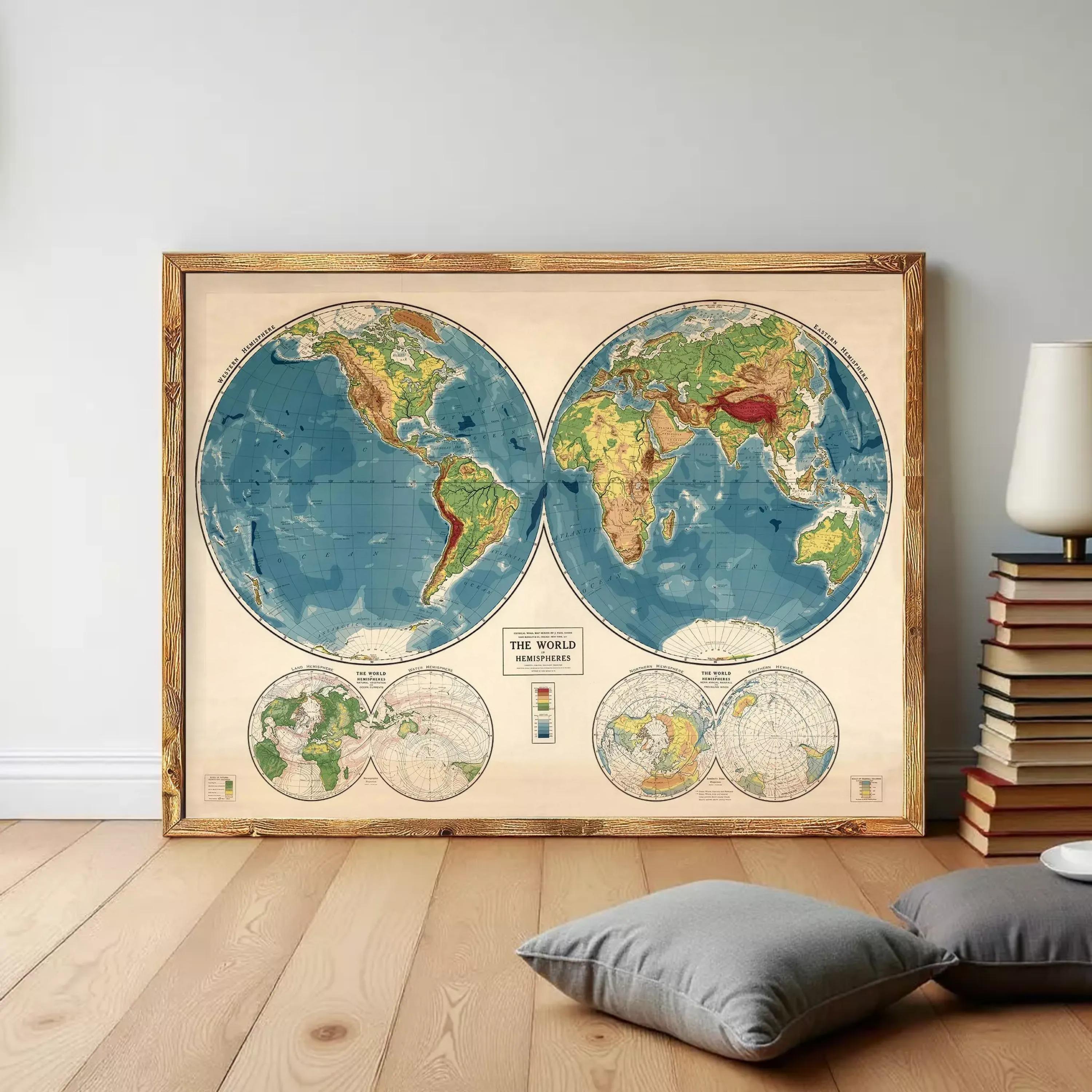 a large, framed vintage world map with two hemispheres, one on each side of the frame. The map is set against a white wall, and there are some books and pillows visible in the foreground.