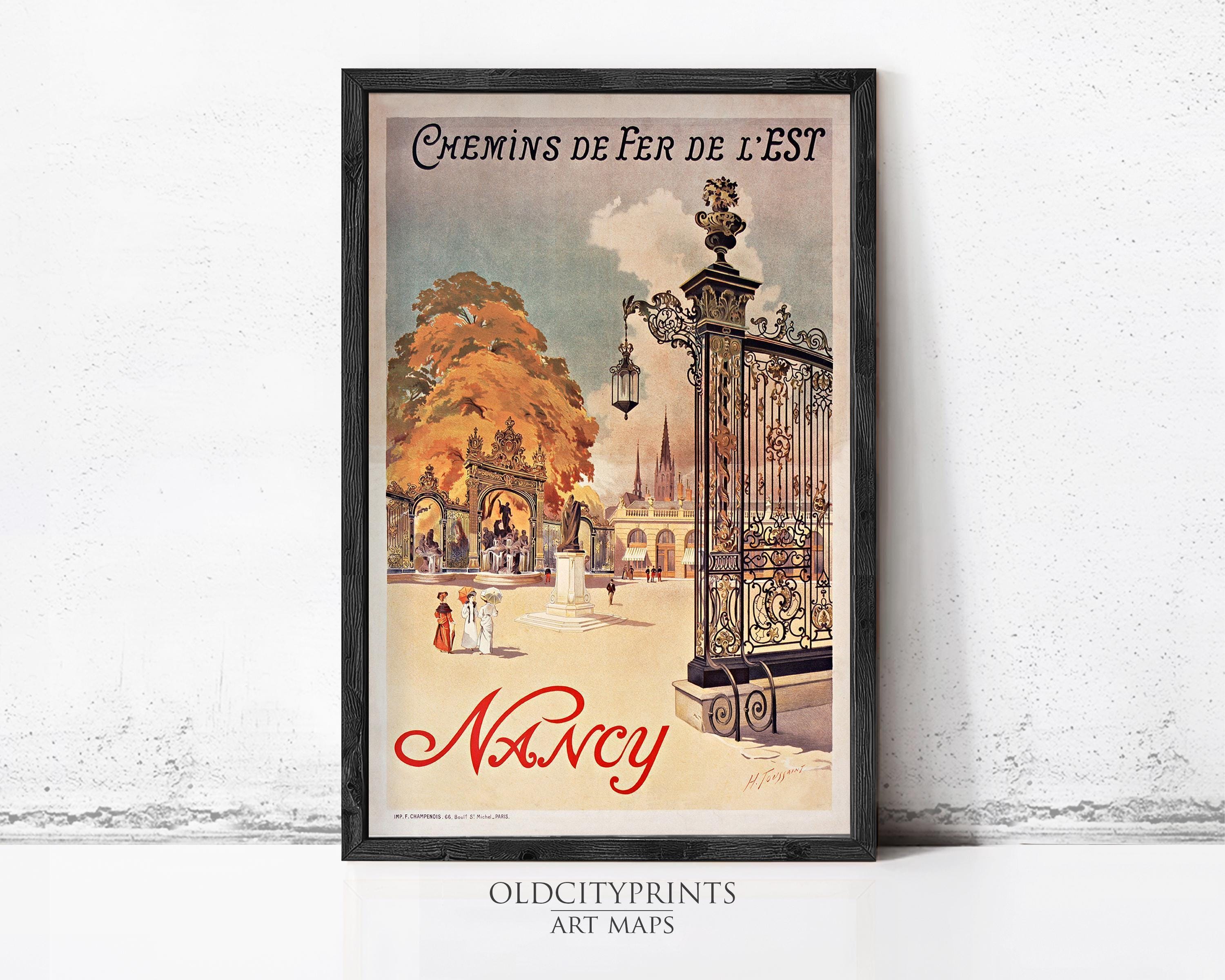 A framed vintage poster advertising Nancy, featuring an illustration of a park scene with people and ornate architecture.
