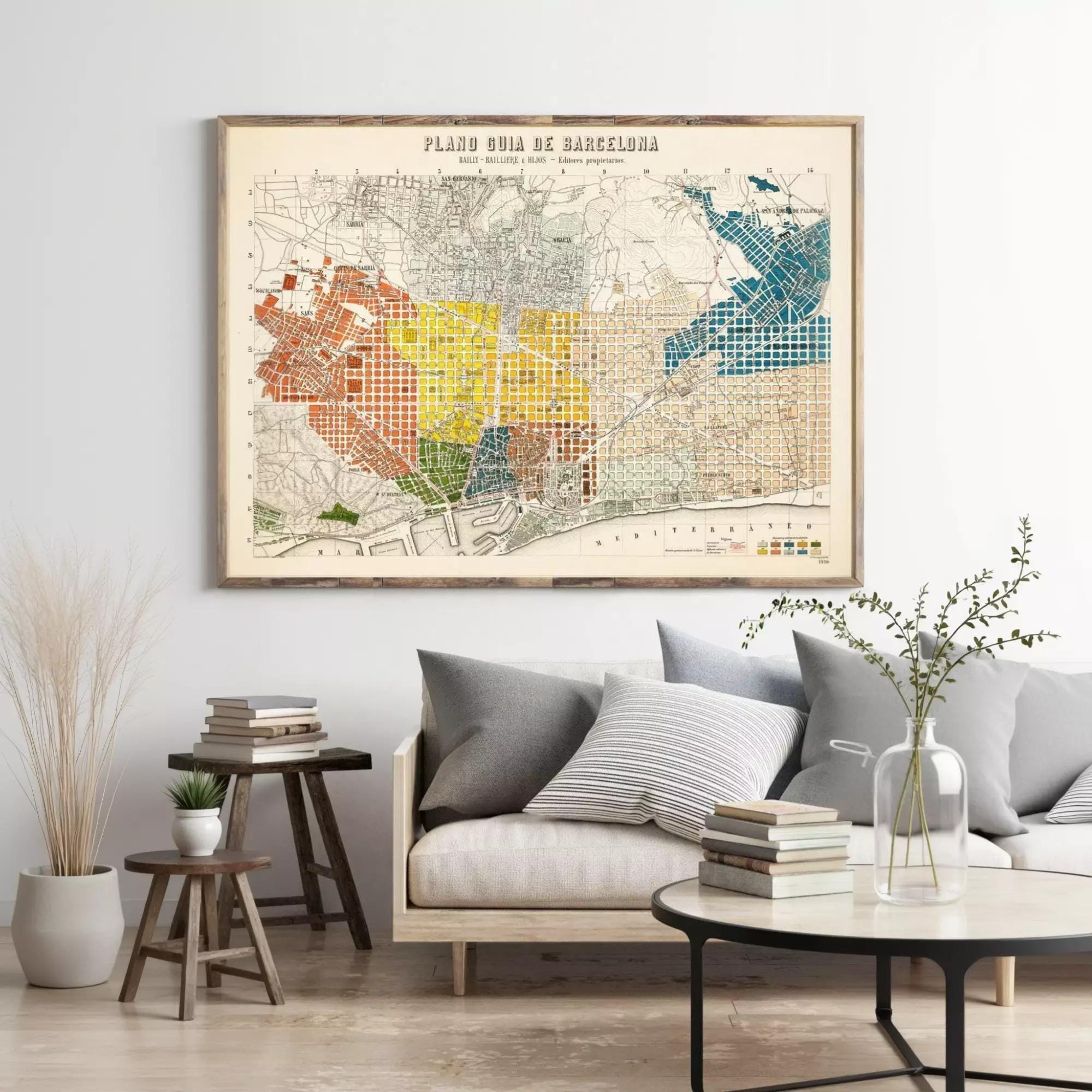 a large, colorful map of Barcelona hanging on a wall above a couch and a coffee table in a living room setting.