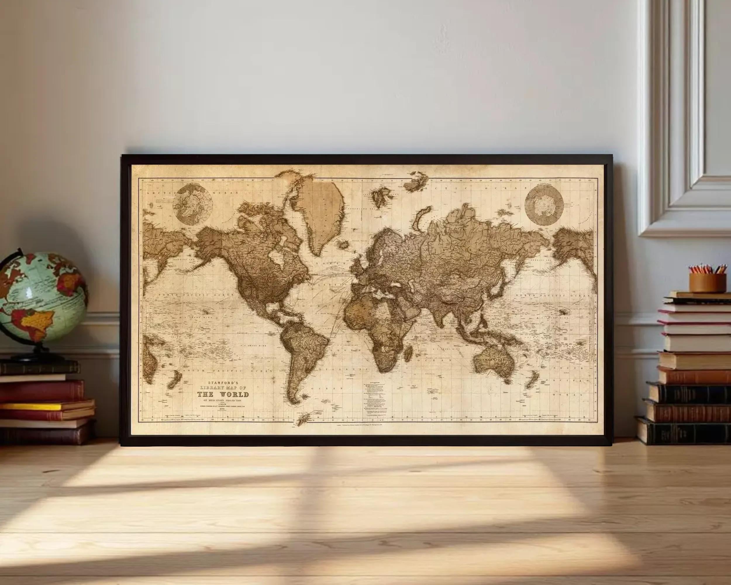 A framed antique world map is displayed on a wooden floor, surrounded by stacks of books and a globe.