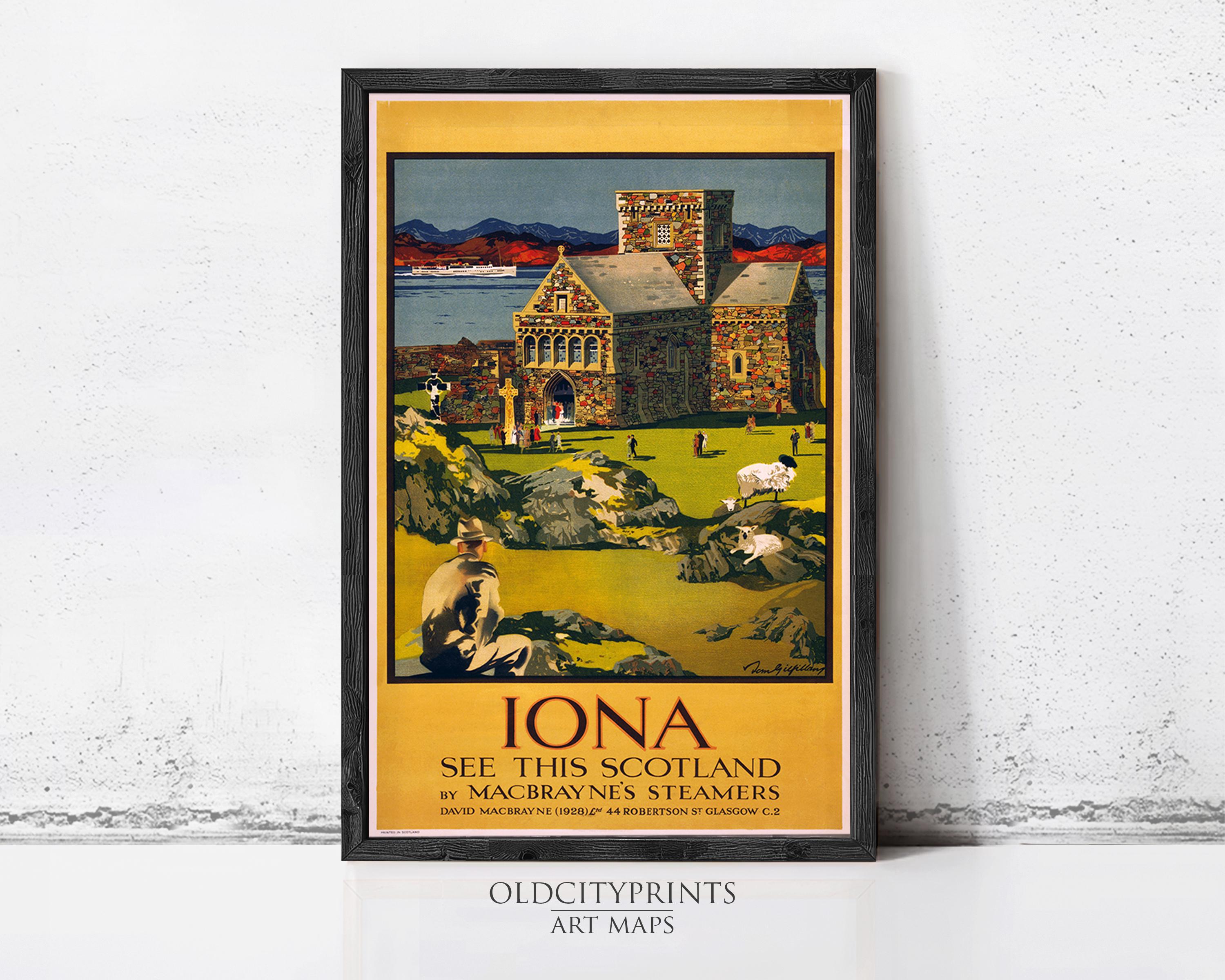 The image is a framed vintage travel poster advertising Iona, a scenic destination in Scotland. The poster features a colorful illustration of a castle, a man sitting on a rock, and a body of water, all set against a backdrop of mountains. The poster is framed by a black border and is displayed on a white wall.