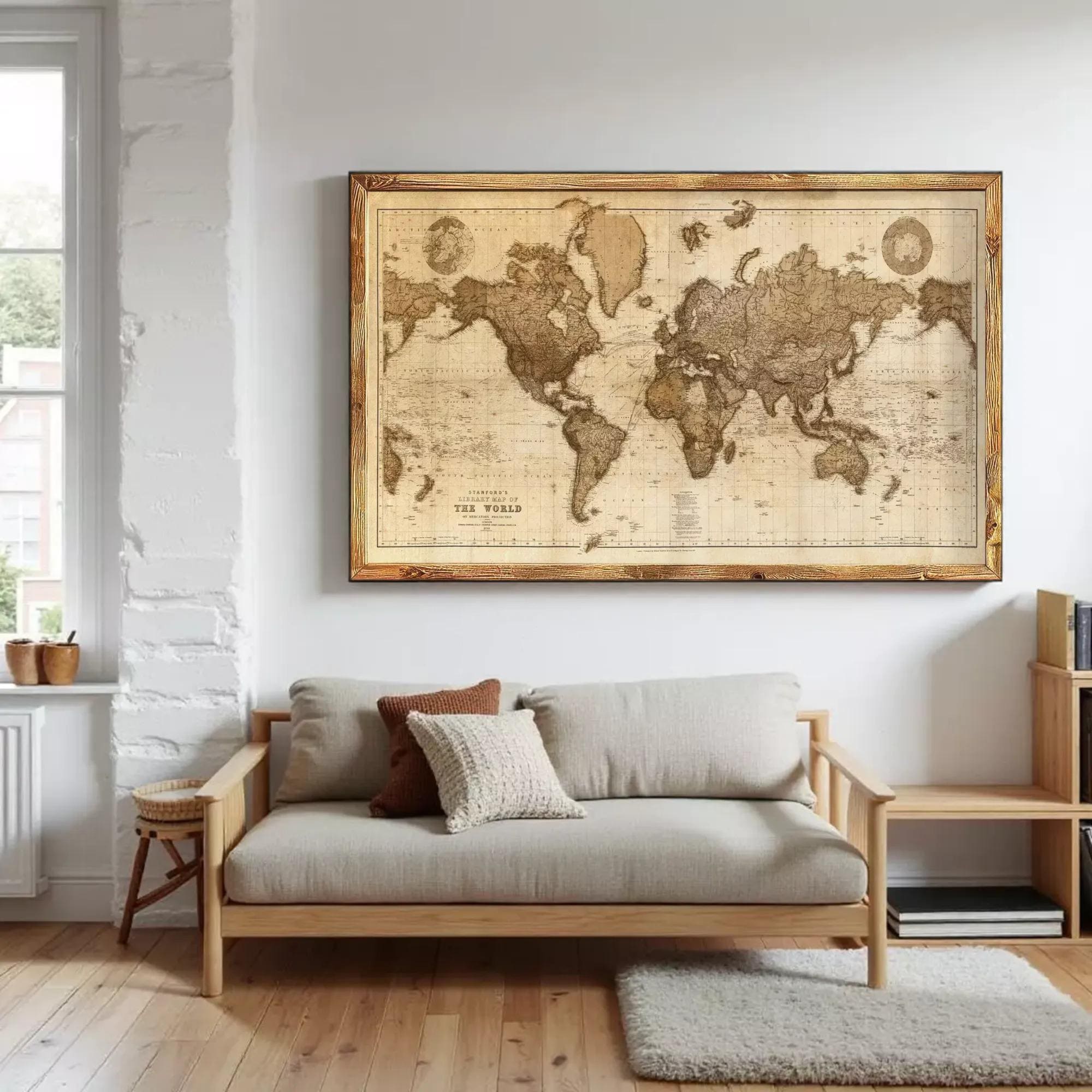 a large world map hanging on a white wall above a gray sofa with a wooden frame.