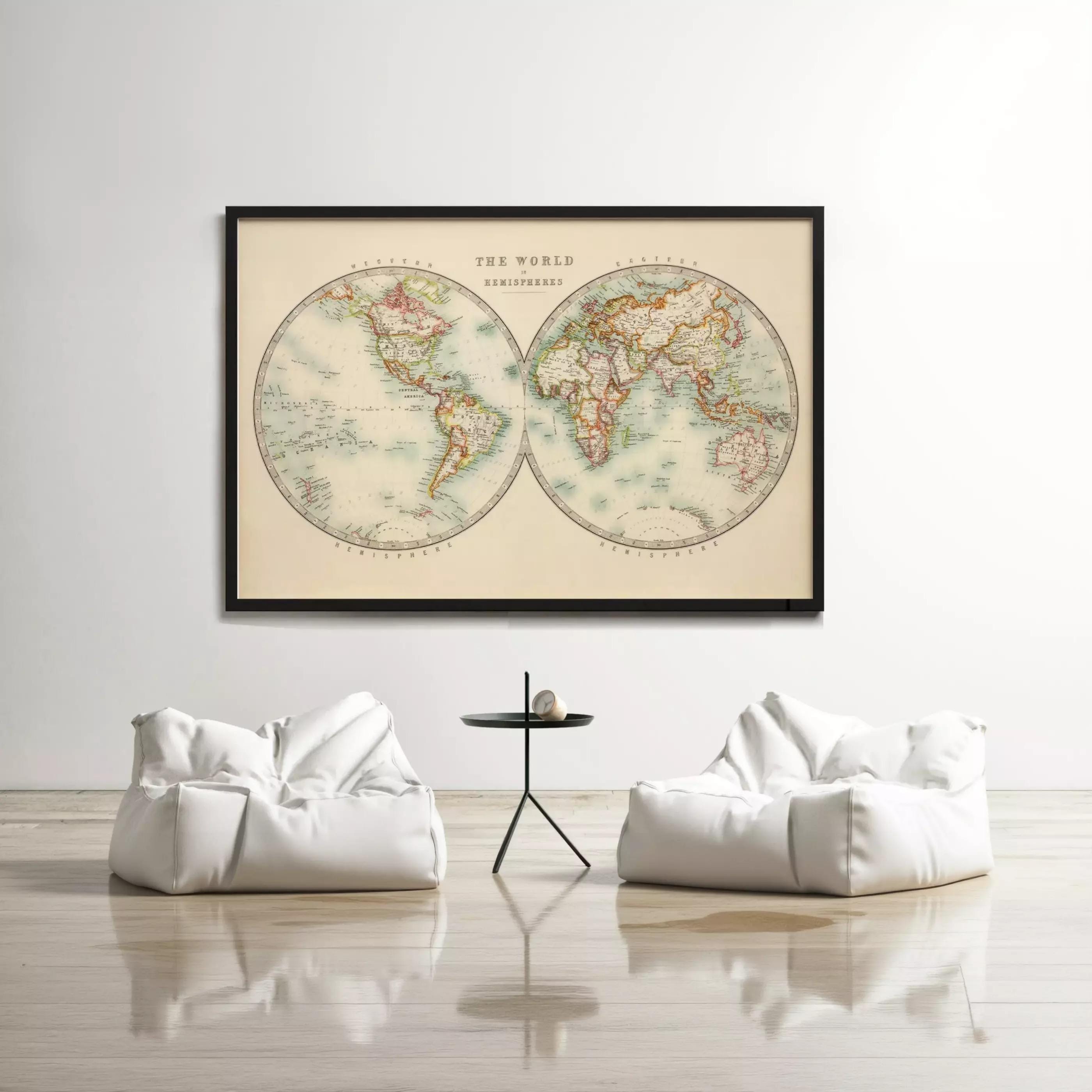 a large world map hanging on a white wall, with two white bean bag chairs positioned in front of it.
